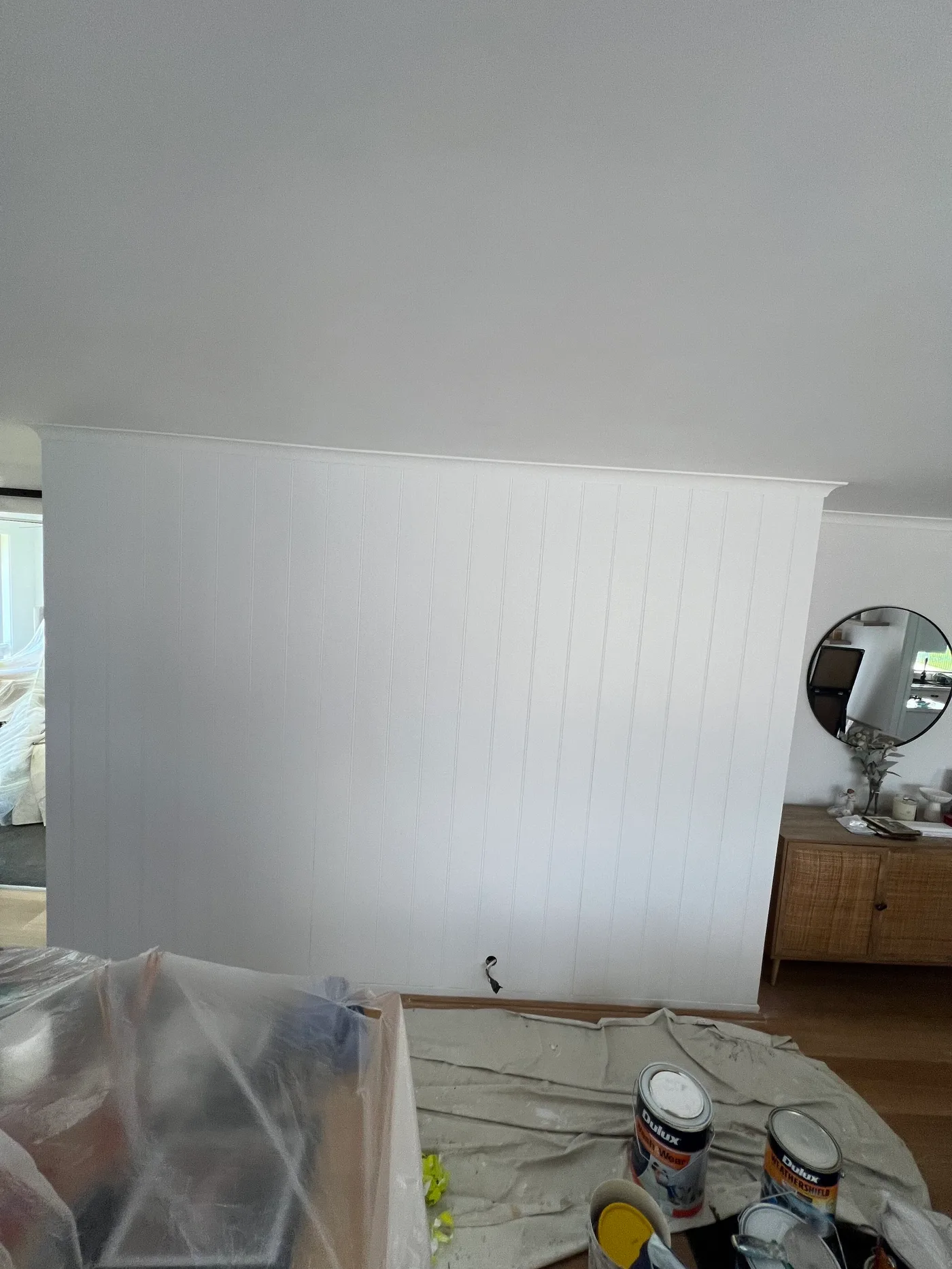 Interior room prepared for painting with drop sheets and paint supplies